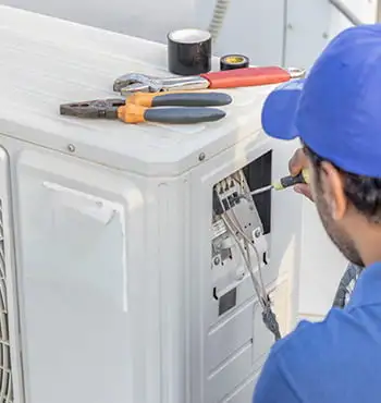 Technician repairing an air conditioner unit