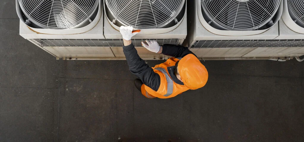 AC technician inspecting commercial air conditioning unit